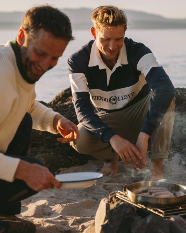 Stylish man in nautical attire at a marina at sunset